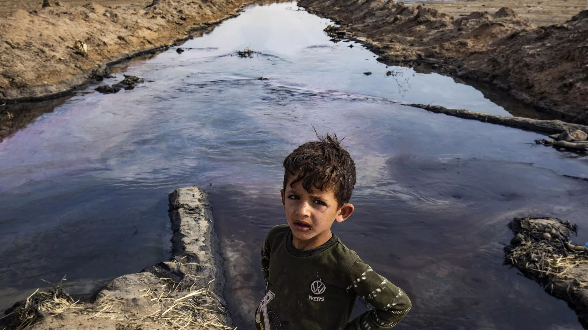 A child poses for a picture on the banks of a river polluted by a nearby oil field in the countryside of Rmeilan, in Syria's northeastern Hasakeh province on August 14, 2023.  - Sputnik International, 1920, 11.09.2023