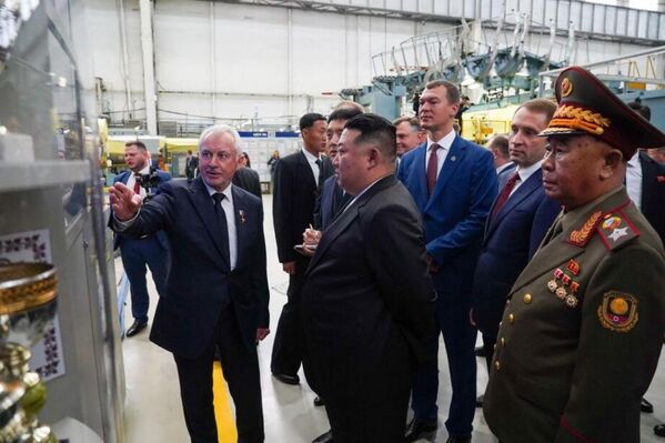 The DPRK leader and Khabarovsk governor listen to an employee guiding them who explains the characteristics of aircraft produced at the  plant. - Sputnik International
