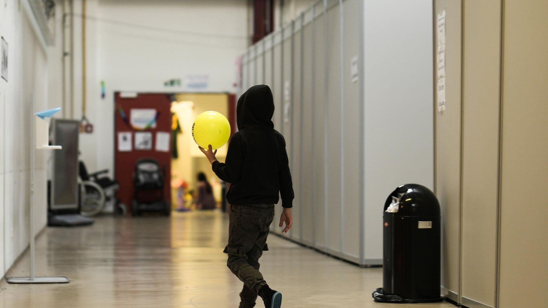 A boy with a ball walks alongside makeshift sleeping units inside the temporary refugee shelter at the former airport Tegel in Berlin, Germany, Wednesday, Nov. 9, 2022.  - Sputnik International, 1920, 18.09.2023