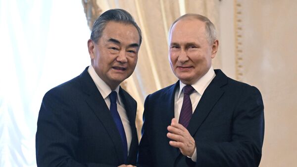 Russian President Vladimir Putin and Chinese Foreign Minister Wang Yi shake hands before a meeting at the Constantine (Konstantinovsky) Palace in Strelna near St. Petersburg, Russia, September 20 - Sputnik International