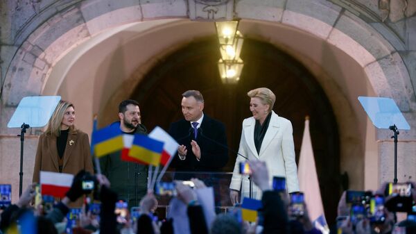 Polish President Andrzej Duda (2nd R) and his wife Agata (R) wave to wellwishers alongside Ukrainian President Volodymyr Zelensky (2nd L) and his wife Olena (L) in the courtyard of the Royal Castle in Warsaw, Poland, on April 5, 2023. - Sputnik International