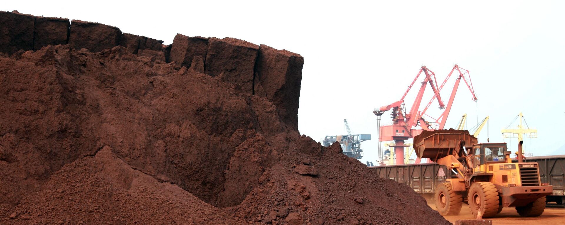
In a picture taken on September 5, 2010 a man driving a front loader shifts soil containing rare earth minerals to be loaded at a port in Lianyungang, east China's Jiangsu province, for export to Japan.  - Sputnik International, 1920, 24.09.2023