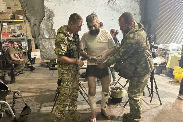 Military doctors helping a wounded man - Sputnik International