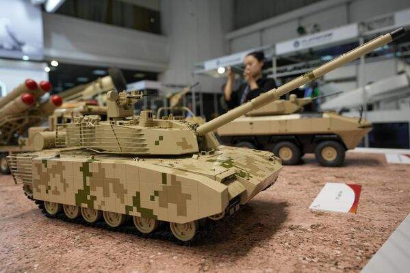 A woman takes a picture of models of battle tanks. - Sputnik International