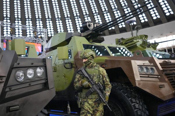 A soldier stands near APCs at the 11th International Armament and Military Equipment Fair in Belgrade, Serbia. - Sputnik International