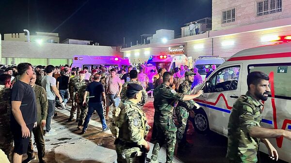 Soldiers and emergency responders gather around ambulances carrying wounded people after a fire broke out during a wedding at an event hall, outside the Hamdaniyah general hospital in Al-Hamdaniyah, Iraq on September 27, 2023. At least 100 people were killed and more than 150 injured when a fire broke out during a wedding at an event hall in the northern Iraqi town of Al-Hamdaniyah, according to state media and health officials, on September 27, 2023.  - Sputnik International