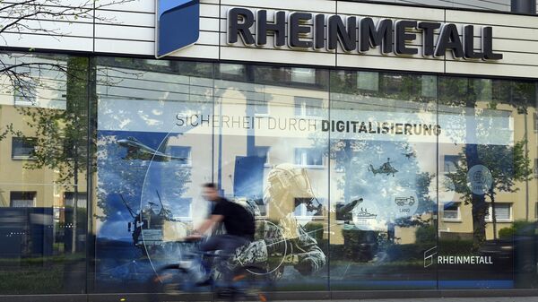 A cyclist rides past the logo of German defence company and automotive supplier Rheinmetall at their headquarters in Duesseldorf, western Germany, on April 21, 2022. - Sputnik International