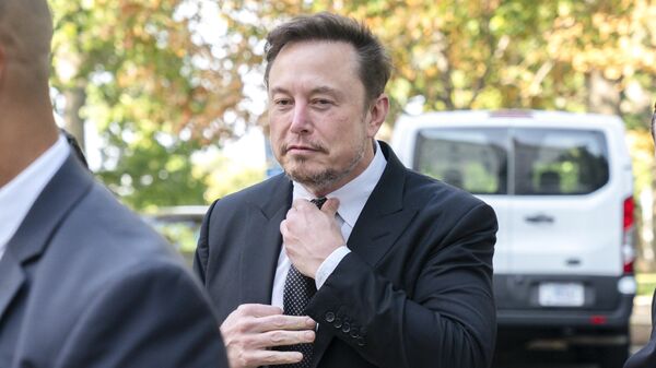 Elon Musk, CEO of X, the company formerly known as Twitter, tightens his tie as he arrives for a closed-door gathering of leading tech CEOs to discuss the priorities and risks surrounding artificial intelligence and how it should be regulated, at Capitol Hill in Washington, Wednesday, Sept. 13, 2023. - Sputnik International
