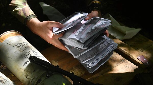 A Russian serviceman holds in his hands leaflets for propaganda shells in the Svatovsky direction. - Sputnik International