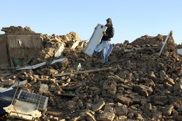 An Afghan man removes debris after an earthquake. - Sputnik International