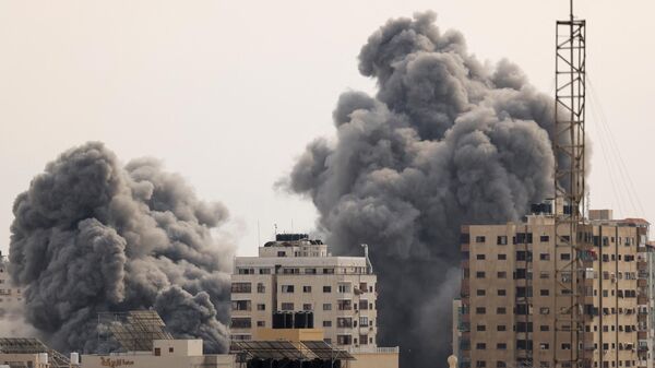 A black plume of smoke billows behind highrise buildings in the sky during an Israeli airstrike on Gaza City on October 9, 2023.  - Sputnik International