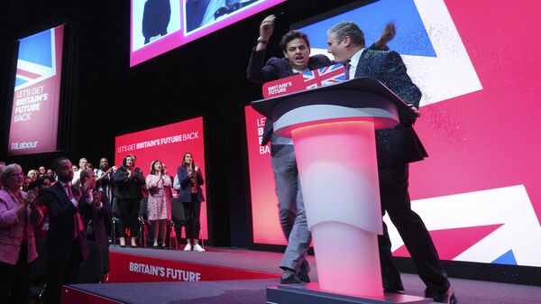 An unidentified man throw confetti as Britain's opposition Labour Party leader Keir Starmer speaks at the Labour Party conference in Liverpool, England, Tuesday, Oct. 10, 2023. - Sputnik International