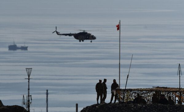 A military chopper flies by as servicemen check a mock stronghold during the Indestructible Brotherhood-2023 joint military drills. - Sputnik International