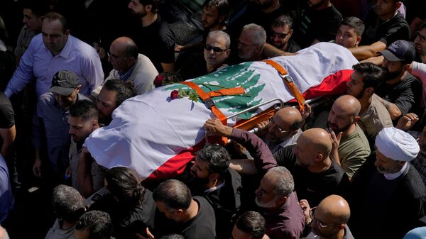 Mourners carry the body of Reuters videographer Issam Abdallah who was killed by Israeli shelling during his funeral procession in his hometown of Khiam, southern Lebanon, Saturday, Oct. 14, 2023 - Sputnik International