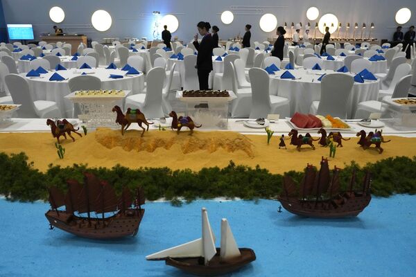 Waitresses preparing for a gala dining event at the media center near a display depicting China&#x27;s Silk Road at the National Convention Center in the Chinese capital. - Sputnik International