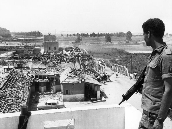 An Israeli soldier watches Palestinian refugees crossing the war-wretched Allenby Bridge to reach the east bank of Jordan 22 June 1967. The June 1967 war was a stunning military victory for Israel, but the start of a political stalemate that continues to this day. During the Six-Day War Israel suffered around 700 fatalities, while estimates of the numbers of Arabs killed range from just over 11,000 to 21,000, with losing the Egyptians paying the heaviest tribute. Israel was left in control of the Sinai, the Gaza Strip, the West Bank and East Jerusalem, as well as the Golan Heights. Some 350,000 Palestinians fled the newly occupied regions to take up residence in neighboring states. Most of them have never been able to return, and are still living in refugee camps. - Sputnik International