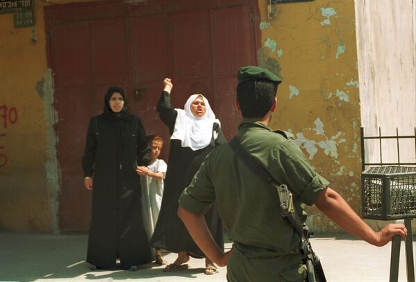 An Arab woman screams abuse at an armed Israeli border policeman after her son was arrested this morning in curfewed Gaza Strip, Occupied Gaza Strip, for hurling stones at troops, May 21, 1990.During that time, the Gaza Strip was under Israeli military occupation as part of the broader Palestine-Israel conflict. The Israeli military had imposed curfews and various restrictions on the movement of Palestinians in the area, as part of their efforts to maintain control and security in the region.Palestinians throwing rocks at Israeli soldiers were often during that time and were often expressions of frustration, anger, and resistance to Israeli military presence and control. The throwing of stones was seen as a symbol of Palestinian resistance, particularly among Palestinian youth.It was common for Palestinian stone-throwers to face arrest by Israeli security forces. The response to such incidents often included arrests, detentions, and sometimes more severe measures, depending on the circumstances and the severity of the protest.Overall, such incidents reflect the tense and challenging environment in the Gaza Strip during the period of Israeli occupation, where confrontations between Palestinian residents and Israeli forces were relatively common forms of protest and resistance. - Sputnik International