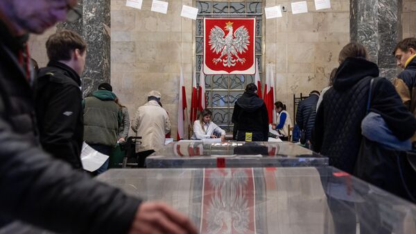 People cast their votes in the polling station at the Palace of Culture in Warsaw, Poland on October 15, 2023, during parliamentary elections. - Sputnik International