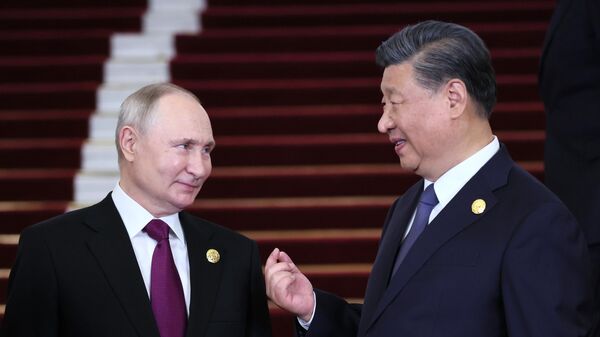 Russian President Vladimir Putin listens to Chinese President Xi Jinping during a welcoming ceremony for heads of delegations participating in the 3rd Belt and Road Forum for International Cooperation, at the Great Hall of the People in Beijing, China. - Sputnik International