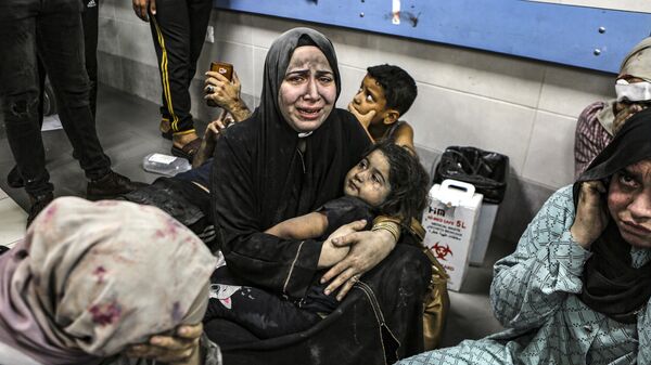 Wounded Palestinians sit in Gaza City's al-Shifa hospital, in the central Gaza Strip - Sputnik International
