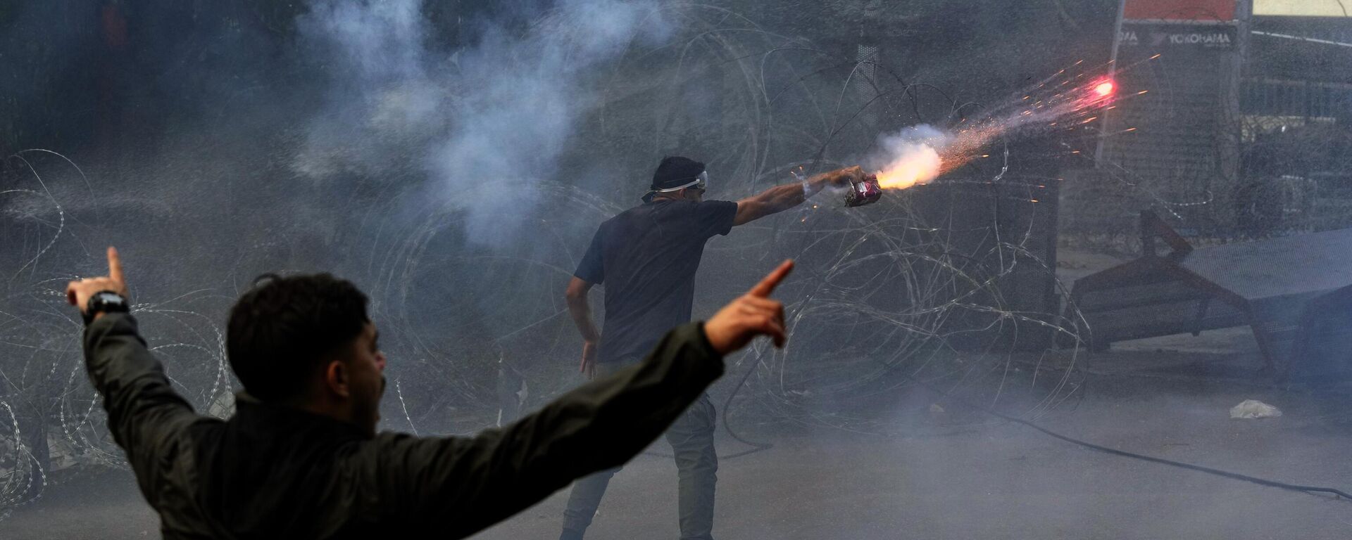 Протестующий запускает фейерверк в ОМОН во время демонстрации в знак солидарности с палестинским народом в Газе, возле посольства США в Аукаре - Sputnik International, 1920, 19.10.2023