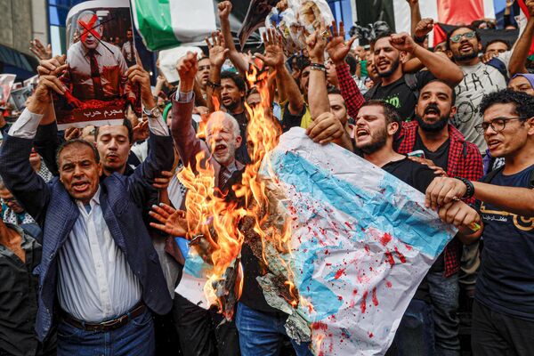 .Egyptians burn Israeli flags as they take part in a demonstration outside the Syndicate of Journalists in downtown Cairo. - Sputnik International
