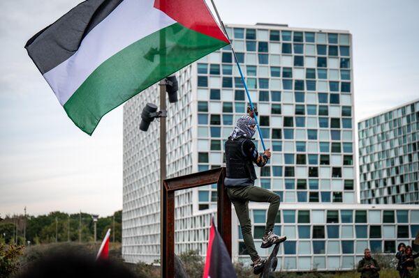 A protestor wearing a Palestinian Keffiyeh scarf takes part in a demonstration in solidarity with Palestinians in front of the International Criminal Court in the Hague. - Sputnik International