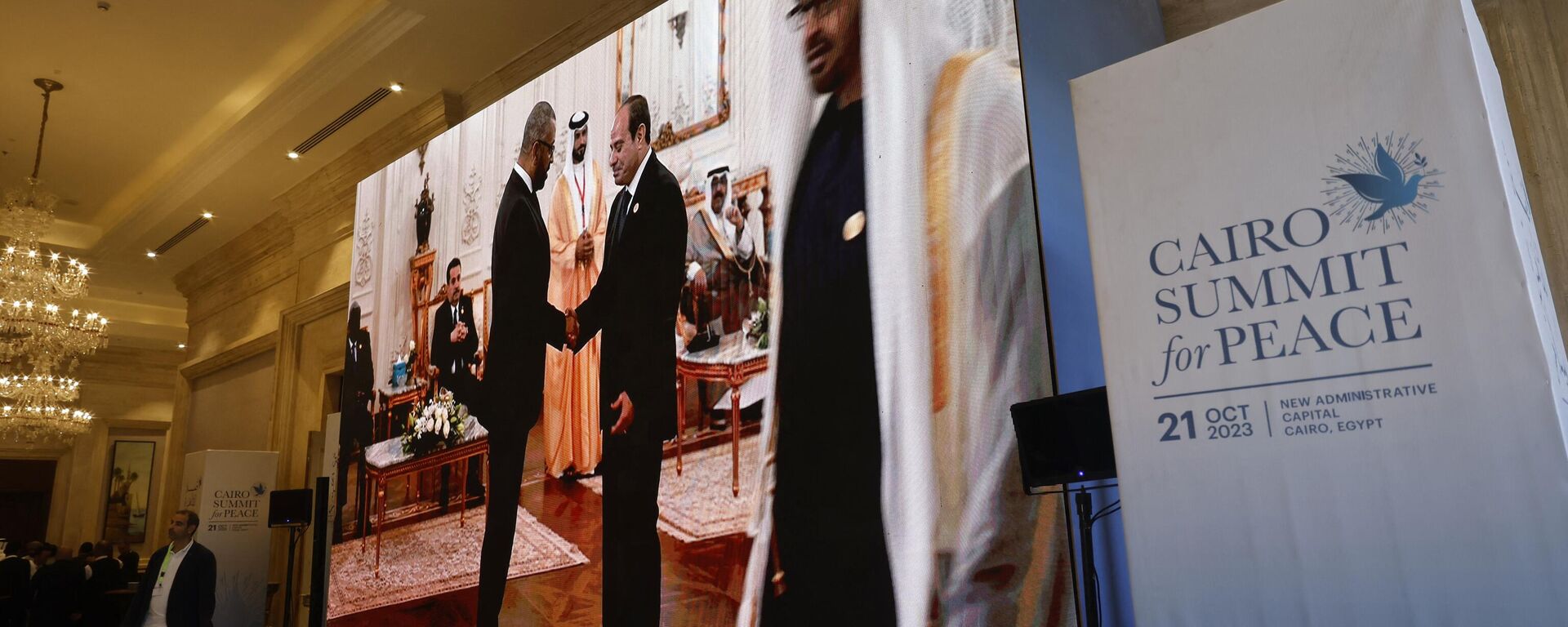 Seen on a large screen the British Secretary of State for Foreign, Commonwealth and Development Affairs James Cleverly is greeted by the Egyptian President Abdel-Fattah al-Sisi (2ndR) prior to the start of the International 'Summit for Peace' hosted by the Egyptian president in Cairo on October 21, 2023. - Sputnik International, 1920, 21.10.2023