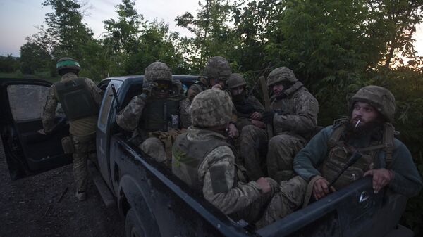 Ukrainian soldiers sit in a pickup truck at their position on the frontline close to Bakhmut, - Sputnik International