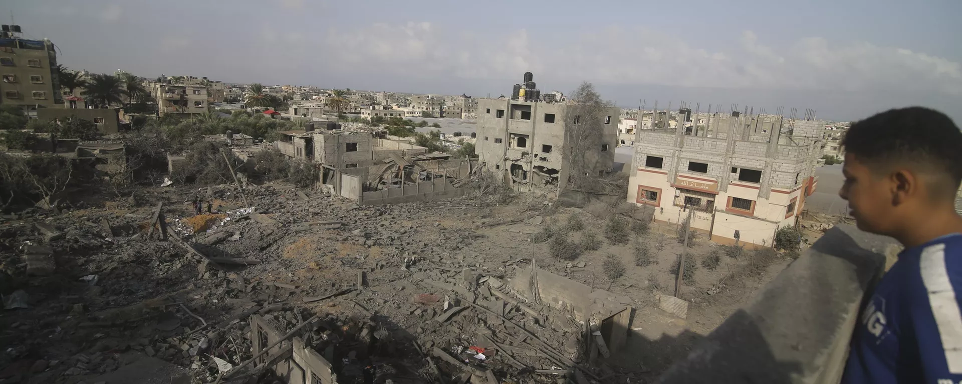 A Palestinian kid looks at he buildings destroyed in the Israeli bombardment of the Gaza Strip in Rafah on October 22, 2023. - Sputnik International, 1920, 15.01.2025