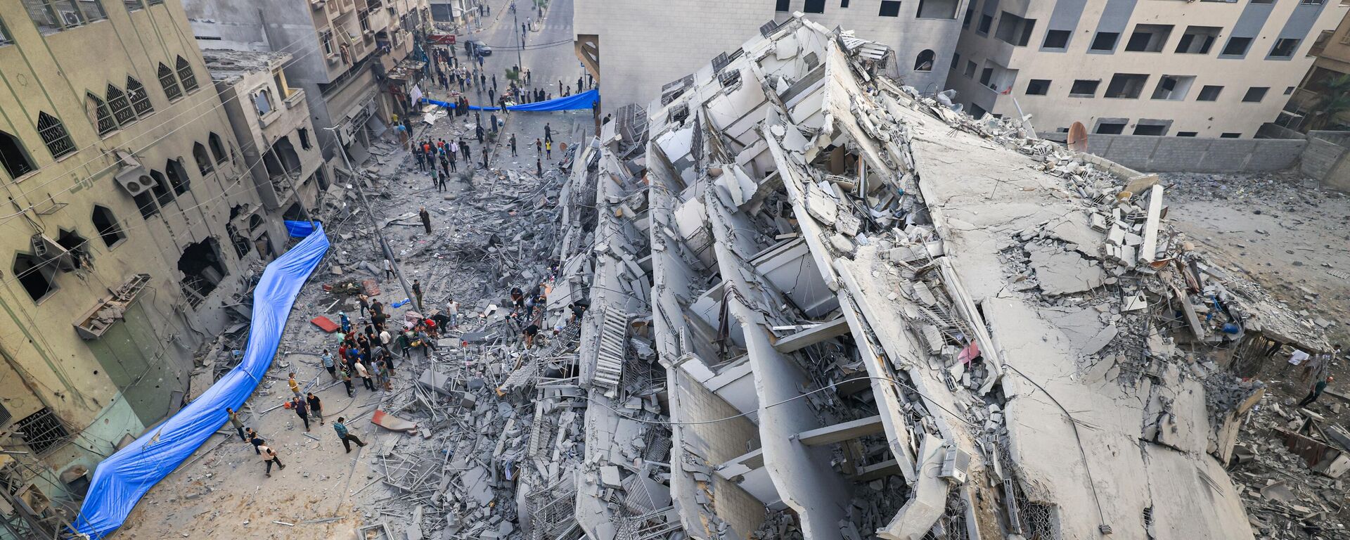 People inspect the ruins of a building destroyed in Israeli strikes in Gaza City on October 8, 2023.  - Sputnik International, 1920, 30.10.2023