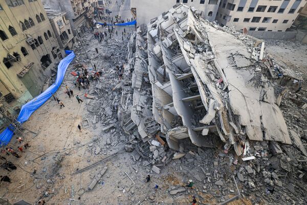 People inspect the ruins of a building destroyed by Israeli strikes in Gaza City on October 8, 2023.  - Sputnik International