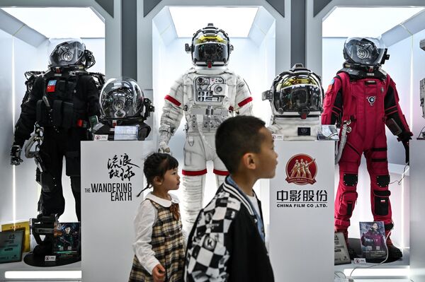 Children walking past space suits of the Chinese sci-fi movie The Wandering Earth on display. - Sputnik International