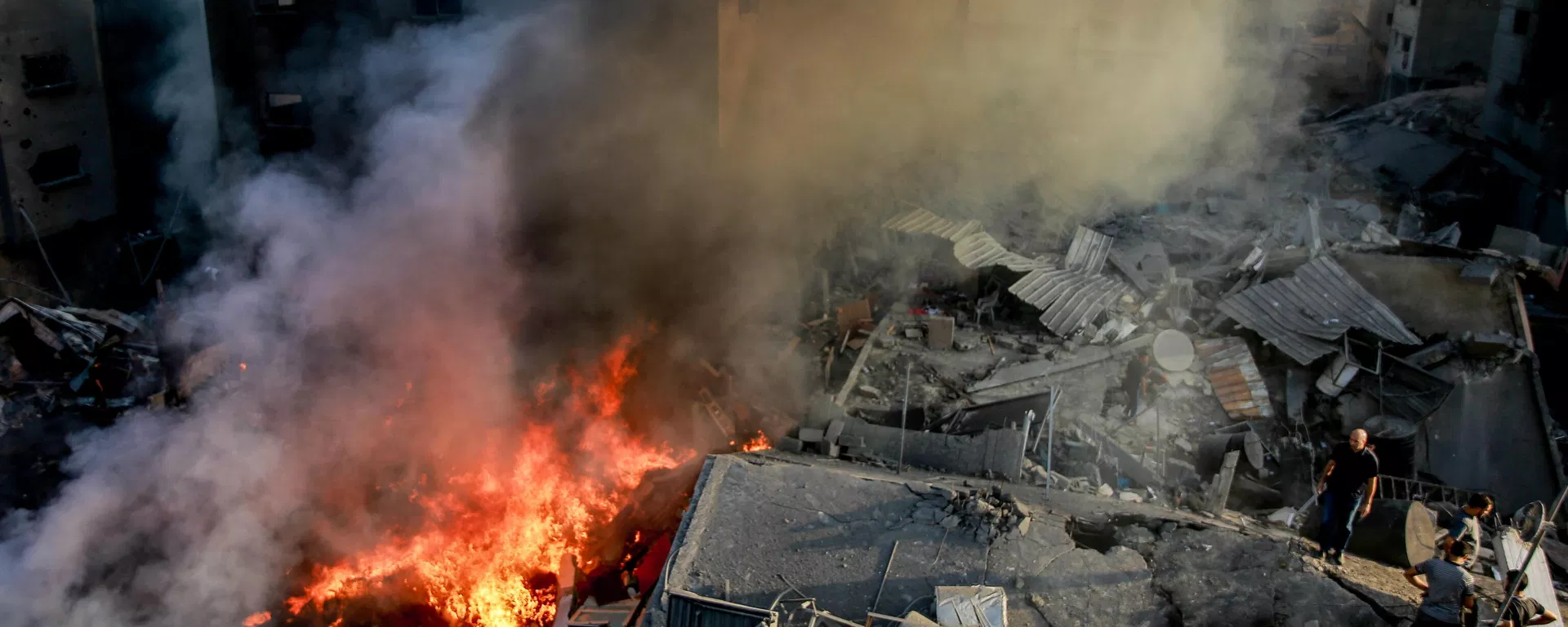 Palestinians stand on the rubble of a levelled building as smoke and fire rise from the destruction following an Israeli strike in Gaza City on October 26, 2023. - Sputnik International, 1920, 19.11.2023