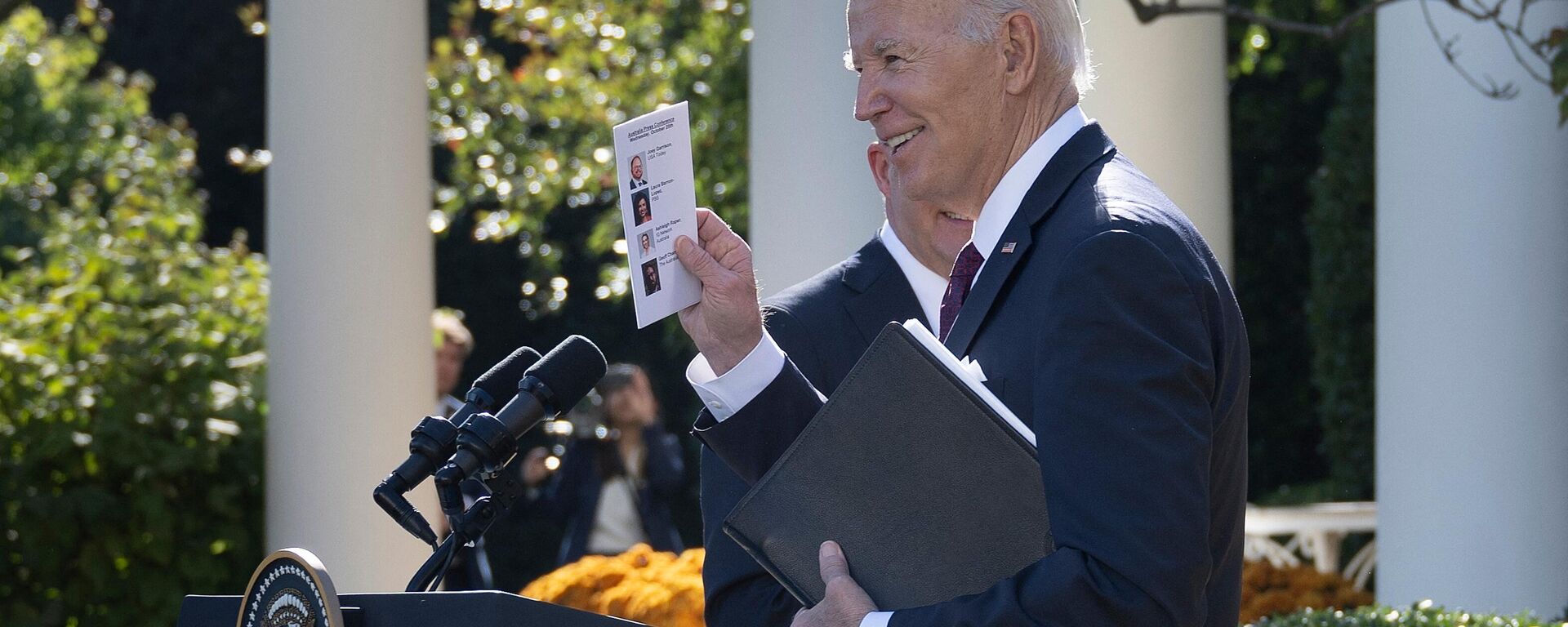 US President Joe Biden and Australia's Prime Minister Anthony Albanese (behind) leave after a joint press conference at the Rose Garden of the White House in Washington, DC, on October 25, 2023. Paper shows names and photos of journalists Biden would ultimately end up calling on. - Sputnik International, 1920, 30.10.2023
