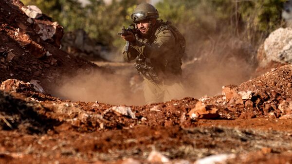 An Israeli army soldier advances during a drill at a position in the upper Galilee region of northern Israel near the border with Lebanon - Sputnik International