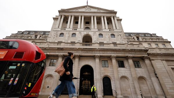 A pedestrian and a London bus go past the Bank of England in London on December 16, 2021. - Sputnik International
