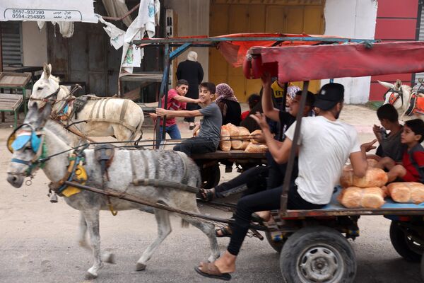 People transport bread as they ride on donkey-pulled carts in Gaza City. - Sputnik International