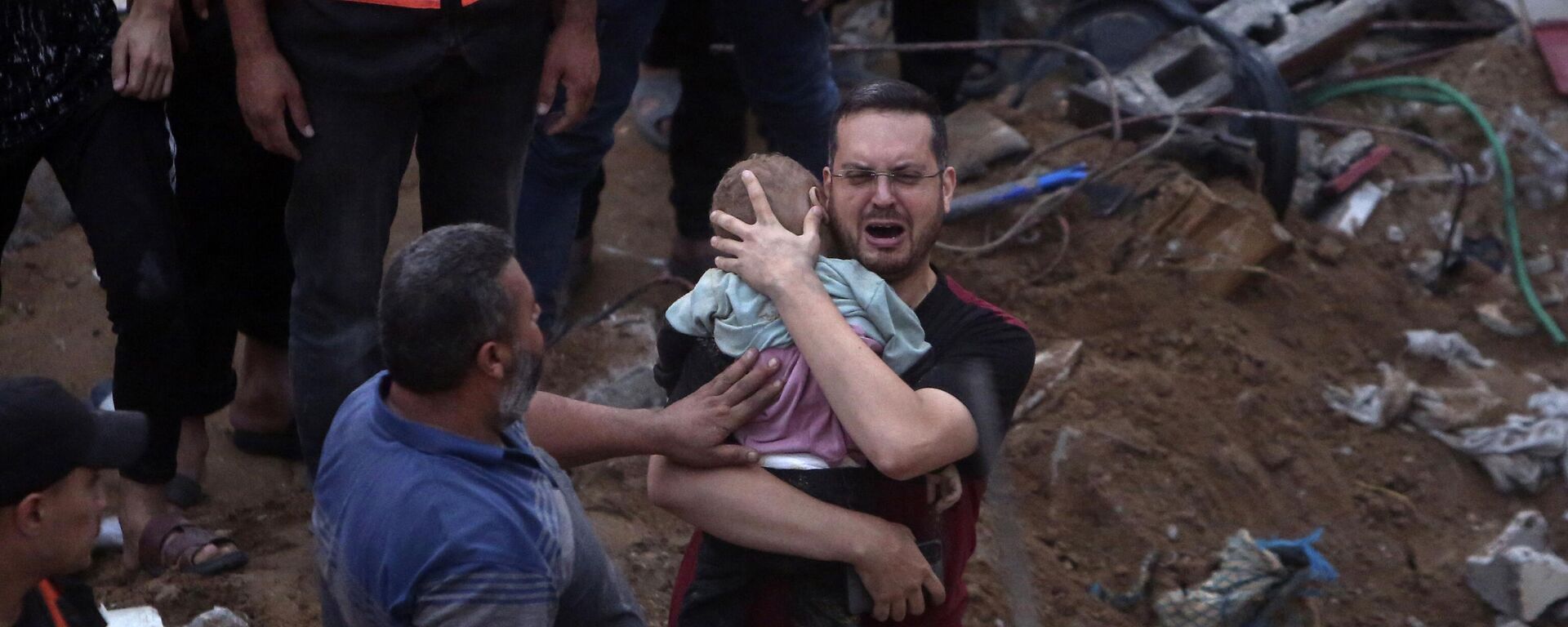 A Palestinian man cries while holding a dead child who was found under the rubble of a destroyed building following Israeli airstrikes in Nusseirat refugee camp, central Gaza Strip, Tuesday, Oct. 31, 2023 - Sputnik International, 1920, 02.11.2023