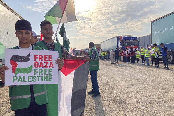 Volunteers boldly wave Palestinian flags and signs at the Rafah border crossing, which connects Egypt and the Gaza Strip.  - Sputnik International