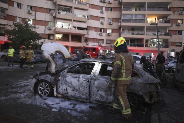 Israeli firefighters inspect the damage to vehicles and a residential building after it was hit by a rocket fired from the Gaza Strip, in Ashdod, southern Israel.  - Sputnik International