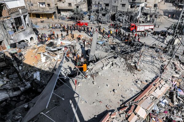 Crowds stand waiting as civil defense workers tirelessly search for victims and survivors in the rubble of a building struck by Israel&#x27;s bombardment in Rafah, located in the southern Gaza Strip. - Sputnik International