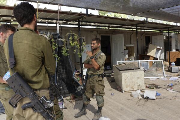 This picture, taken during an Israeli military-led media tour, shows soldiers standing outside a ransacked house in the Nir Oz kibbutz, one of several Israeli communities near the Gaza Strip that fell victim to the infamous ambush by the Hamas Palestinian militant group on  October 7. - Sputnik International