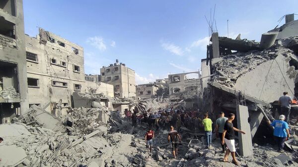 Palestinians inspect the damage of buildings destroyed by Israeli airstrikes on Jabaliya refugee camp on the outskirts of Gaza City, Tuesday, Oct. 31, 2023. - Sputnik International