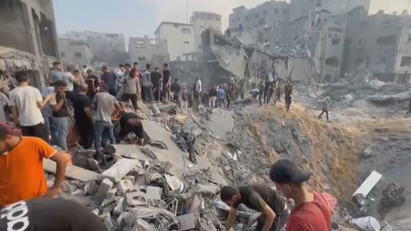 This image grab taken from AFPTV video footage shows Palestinians looking for survivors in a crater following a stike on the Jabaliya refugee camp in the northern Gaza Strip, on October 31, 2023. - Sputnik International