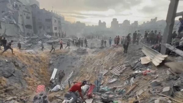 This image grab taken from AFPTV video footage shows Palestinians looking for survivors in a crater following a stike on the Jabaliya refugee camp in the northern Gaza Strip, on October 31, 2023. - Sputnik International