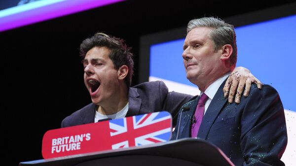 A protester sprinkles British Labour Party Leader Sir Keir Starmer with glitter on the podium of the party's conference in Liverpool on October 10, 2023. - Sputnik International
