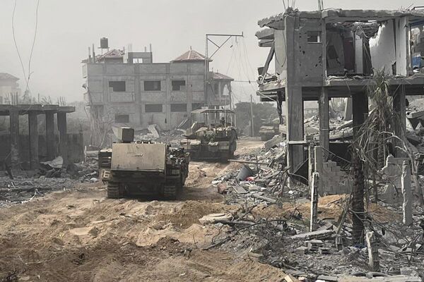 In this undated image distributed by the Israeli military, armored personnel carriers move between destroyed buildings during a ground operation in the Gaza Strip. - Sputnik International