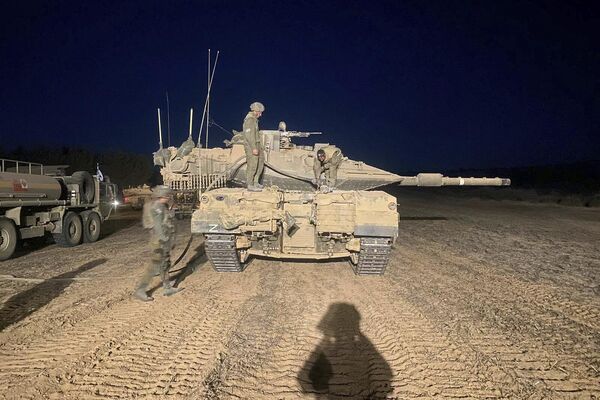 In this undated photo provided by the Israeli military, Israeli soldiers work on a tank during a ground operation in the Gaza Strip.  - Sputnik International