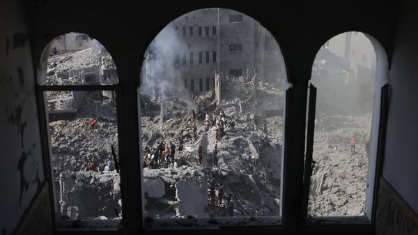 People sift through the smouldering rubble of buildings destroyed in an Israeli strike on the Bureij refugee camp in the central Gaza Strip on November 2, 2023.  - Sputnik International